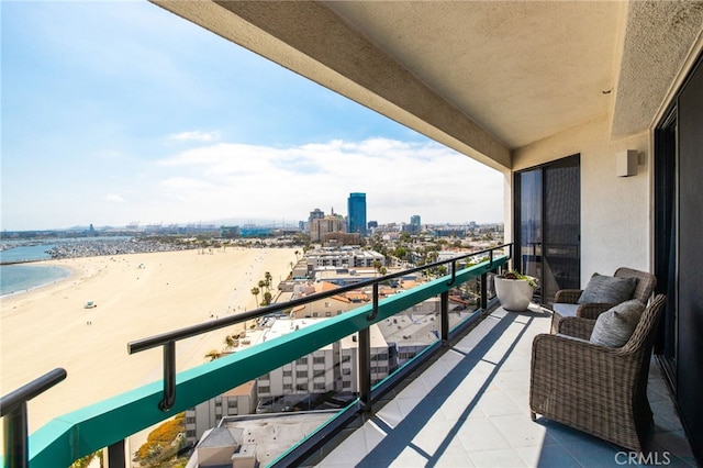 balcony featuring a water view and a beach view