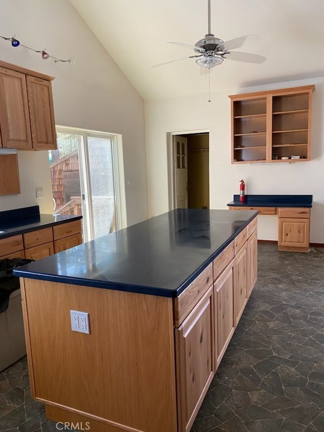 kitchen featuring a kitchen island, ceiling fan, dark tile patterned flooring, and vaulted ceiling