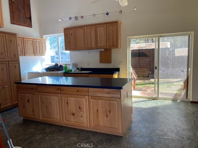 kitchen with dark tile patterned floors, sink, and a kitchen island