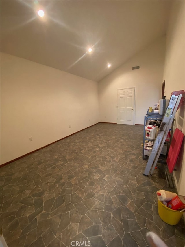 interior space featuring lofted ceiling and dark tile patterned flooring