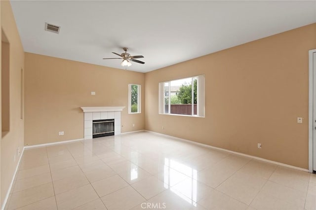 unfurnished living room with a tile fireplace, light tile patterned floors, and ceiling fan