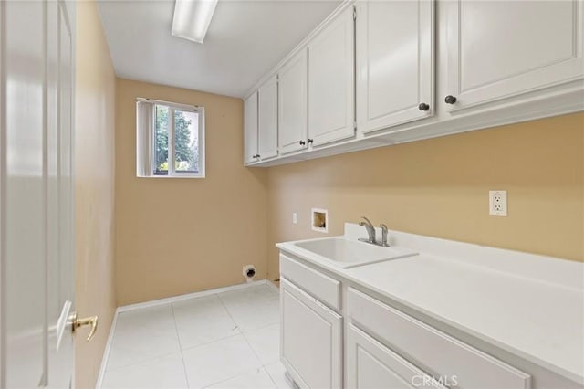 laundry room featuring hookup for a washing machine, sink, light tile patterned floors, and cabinets