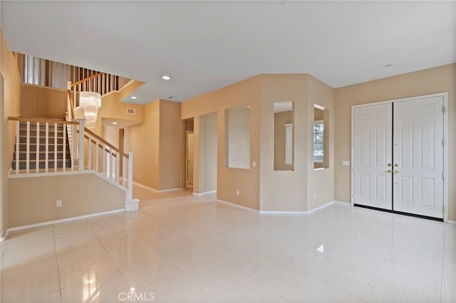 tiled entryway featuring a notable chandelier