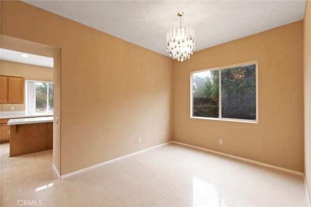 spare room featuring an inviting chandelier