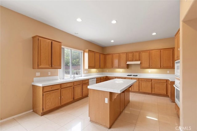 kitchen with tile countertops, light tile patterned floors, a kitchen island, and white appliances