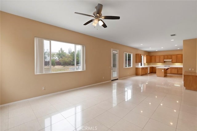 unfurnished living room with ceiling fan and light tile patterned floors