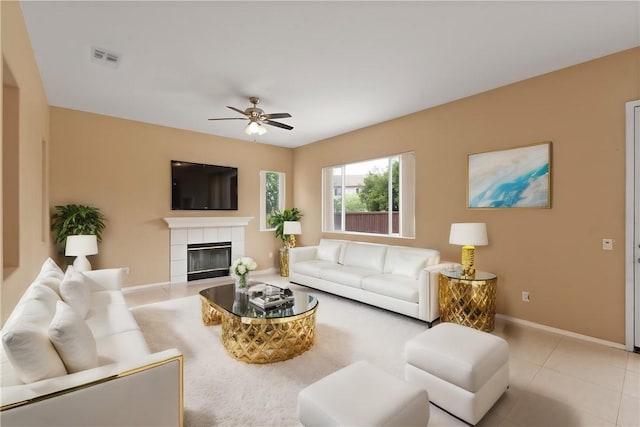 tiled living room featuring ceiling fan and a fireplace