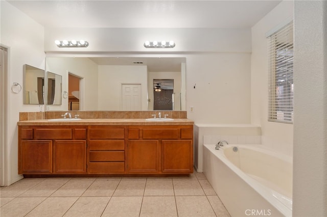 bathroom featuring tile floors, a bath to relax in, oversized vanity, and double sink