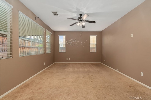 carpeted spare room featuring ceiling fan