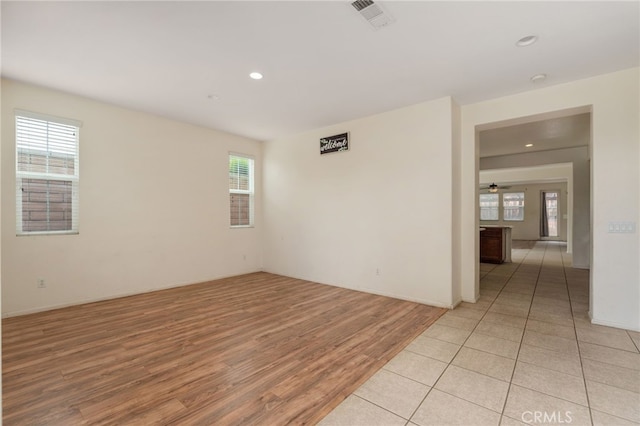 unfurnished room featuring a healthy amount of sunlight, tile flooring, and ceiling fan