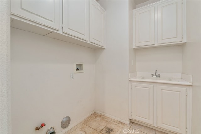 clothes washing area featuring cabinets, gas dryer hookup, hookup for a washing machine, sink, and light tile flooring