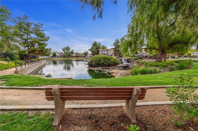 view of home's community with a lawn and a water view