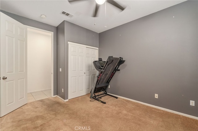 workout area featuring ceiling fan and light colored carpet