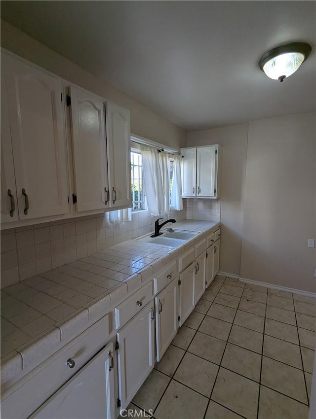 kitchen with tile countertops, white cabinetry, and tasteful backsplash