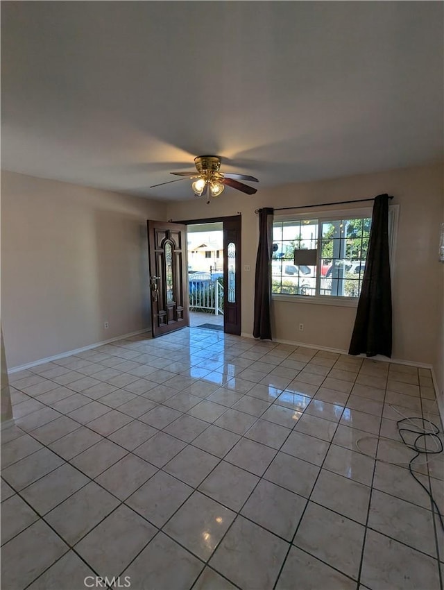 unfurnished room with ceiling fan and light tile patterned floors