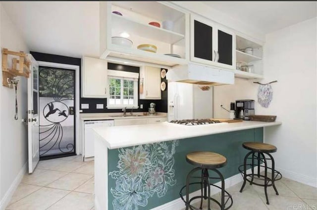 kitchen with dishwasher, white cabinetry, a kitchen breakfast bar, and kitchen peninsula