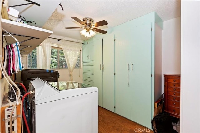 clothes washing area with a textured ceiling, washing machine and dryer, dark hardwood / wood-style floors, and ceiling fan