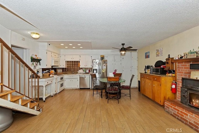 dining area featuring a textured ceiling, light hardwood / wood-style flooring, and ceiling fan