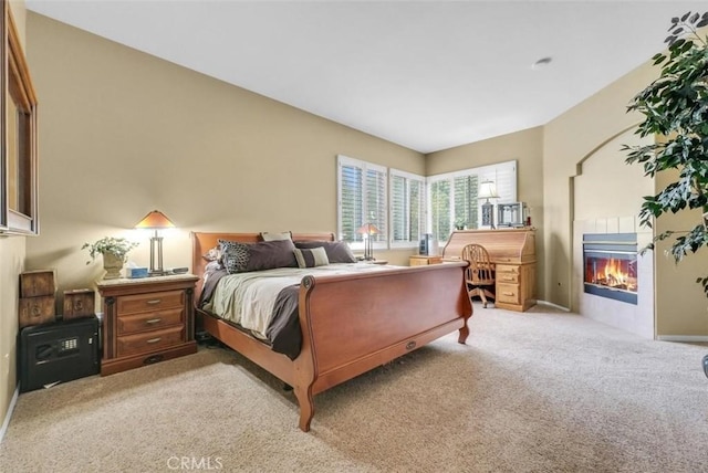 carpeted bedroom with a tile fireplace