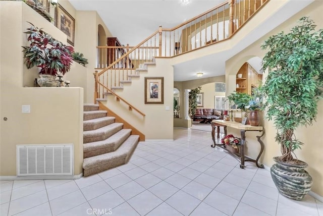 tiled foyer with a towering ceiling