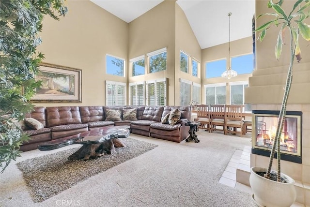 carpeted living room featuring a towering ceiling and a chandelier