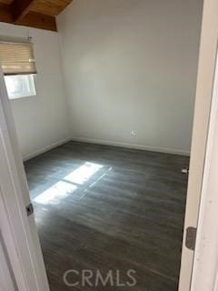 unfurnished room featuring beam ceiling, wooden ceiling, and dark hardwood / wood-style floors