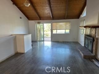 unfurnished living room featuring beamed ceiling, a fireplace, dark hardwood / wood-style flooring, and wooden ceiling