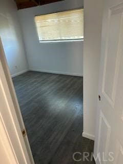 empty room with dark hardwood / wood-style flooring