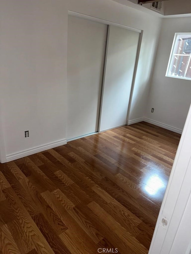 unfurnished bedroom featuring hardwood / wood-style floors and a closet