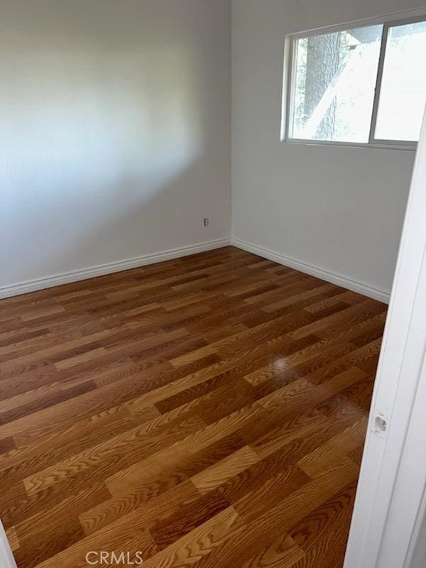 spare room featuring dark wood-type flooring