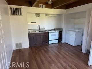 kitchen with white range with gas cooktop, washer / clothes dryer, dark wood-type flooring, and sink