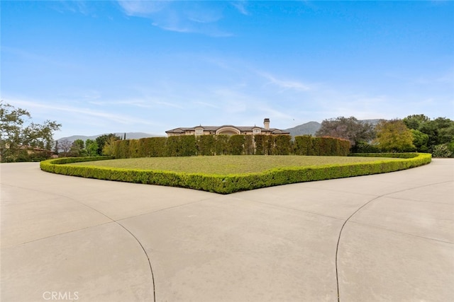 view of property's community with a mountain view and a lawn