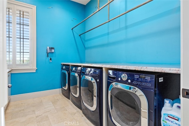 laundry room featuring washing machine and clothes dryer and a wealth of natural light