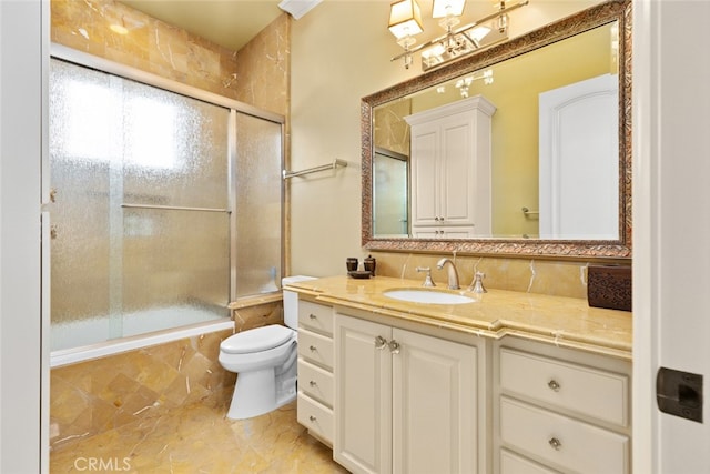 full bathroom featuring vanity, shower / bath combination with glass door, and toilet