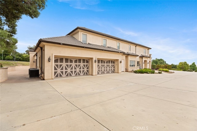 view of front of property featuring a garage and central air condition unit