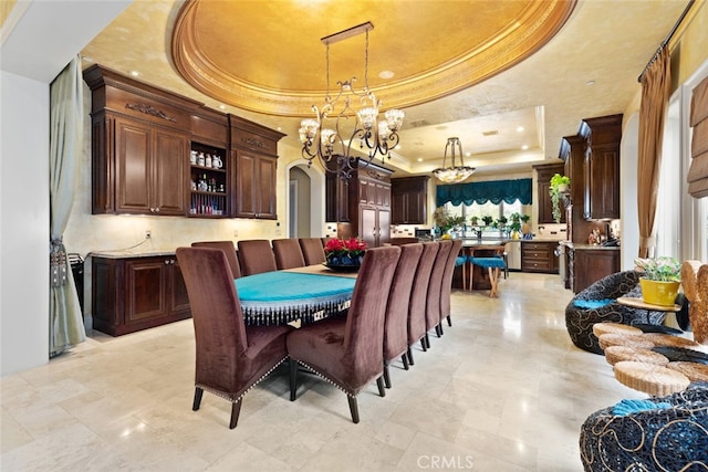 dining room with a notable chandelier and a raised ceiling