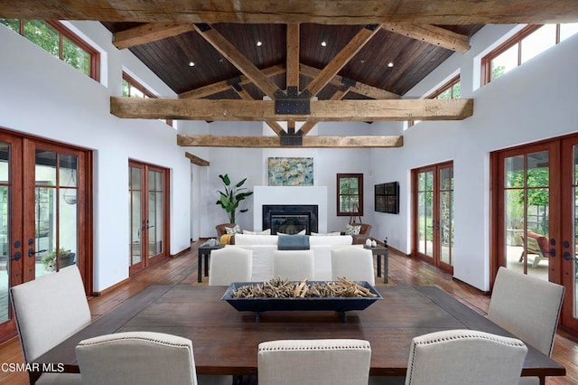 dining room featuring french doors, hardwood / wood-style flooring, high vaulted ceiling, and a wealth of natural light