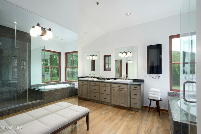 bathroom with vanity, hardwood / wood-style floors, shower with separate bathtub, and vaulted ceiling