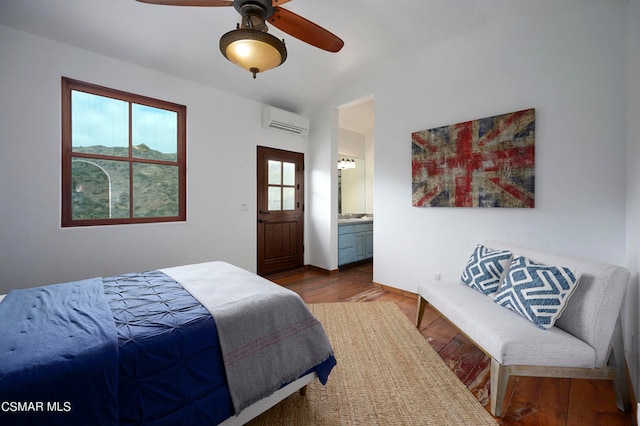 bedroom with ensuite bath, a wall mounted AC, multiple windows, and ceiling fan