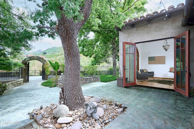 view of yard with french doors, a patio area, and a mountain view