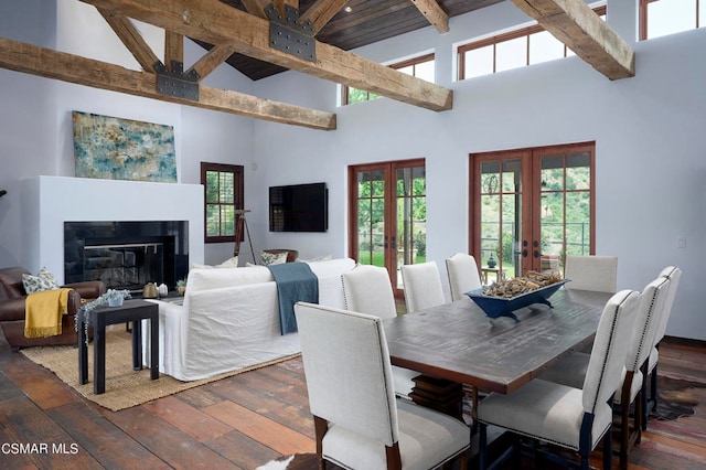 dining room featuring a healthy amount of sunlight, french doors, high vaulted ceiling, and dark hardwood / wood-style flooring