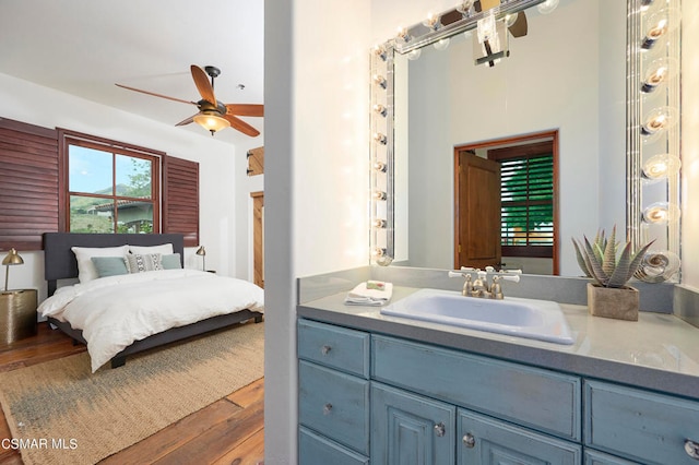 bedroom with dark hardwood / wood-style floors, sink, and ceiling fan