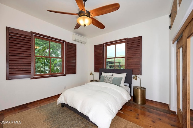 bedroom with an AC wall unit, dark wood-type flooring, multiple windows, and ceiling fan