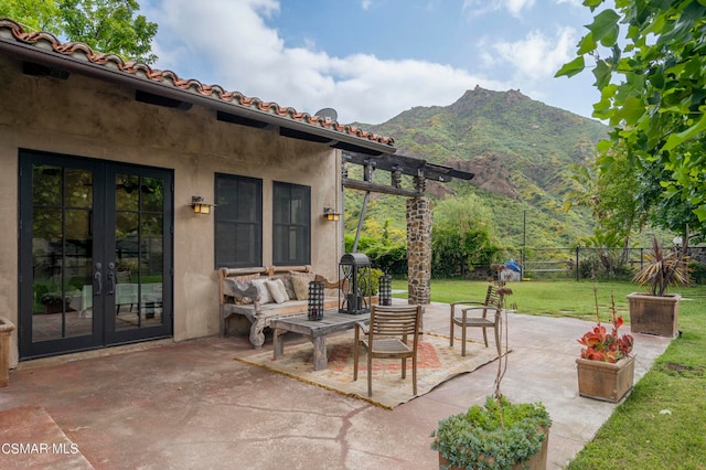 view of patio / terrace with french doors, a mountain view, and outdoor lounge area