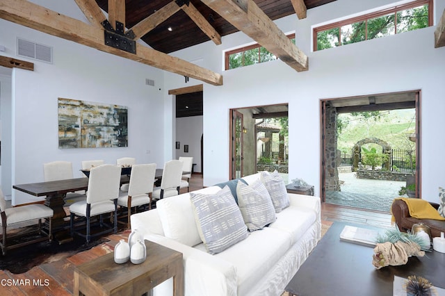 living room with a wealth of natural light, dark wood-type flooring, and high vaulted ceiling