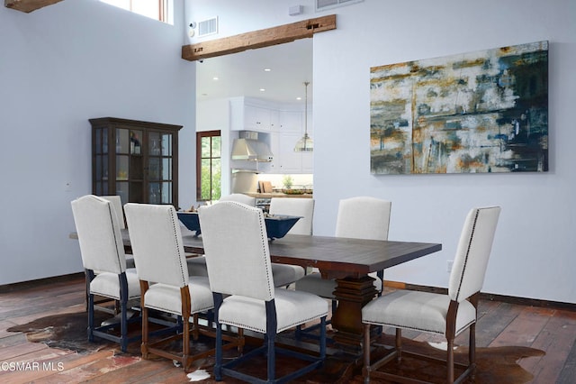 dining area with dark hardwood / wood-style floors and a towering ceiling