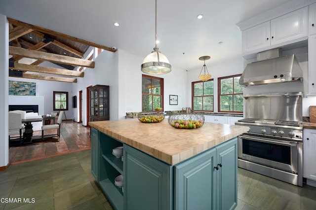 kitchen with butcher block counters, vaulted ceiling with beams, stainless steel range, pendant lighting, and white cabinets