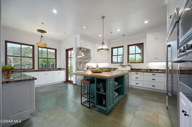 kitchen with extractor fan, white cabinets, wood counters, and a kitchen island