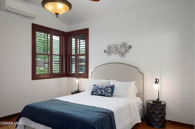 bedroom with a wall unit AC, dark hardwood / wood-style floors, and lofted ceiling