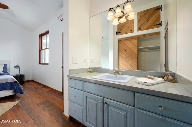 bathroom with vanity, hardwood / wood-style flooring, and lofted ceiling